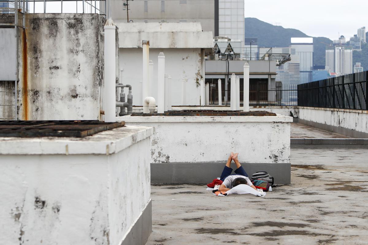 A man sleeps on the rooftop of a residential building in Hong Kong on September 1.