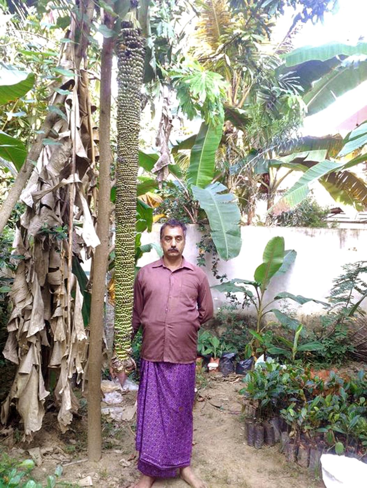 Vinod Sahadevan Nair met een bos Ayiramka Poovan, geteeld op zijn bananenboerderij in Parassala, Thiruvananthapuram  
