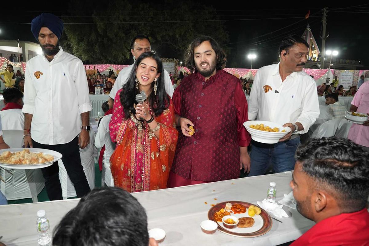 Reliance Industries Chairman Mukesh Ambani’s son and groom Anant Ambani, (centre right), and bride Radhika Merchant (centre left) interacting with guests during a community food service held as part of their pre-wedding celebrations at Jogvad village near Jamnagar.
