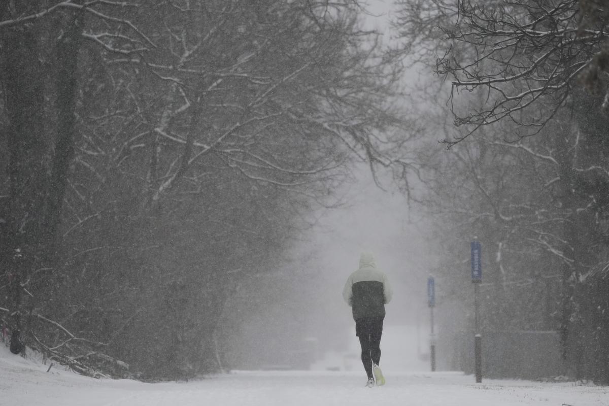 A person runs down a trail during a winter storm, Sunday, Jan. 5, 2025, in Cincinnati. 