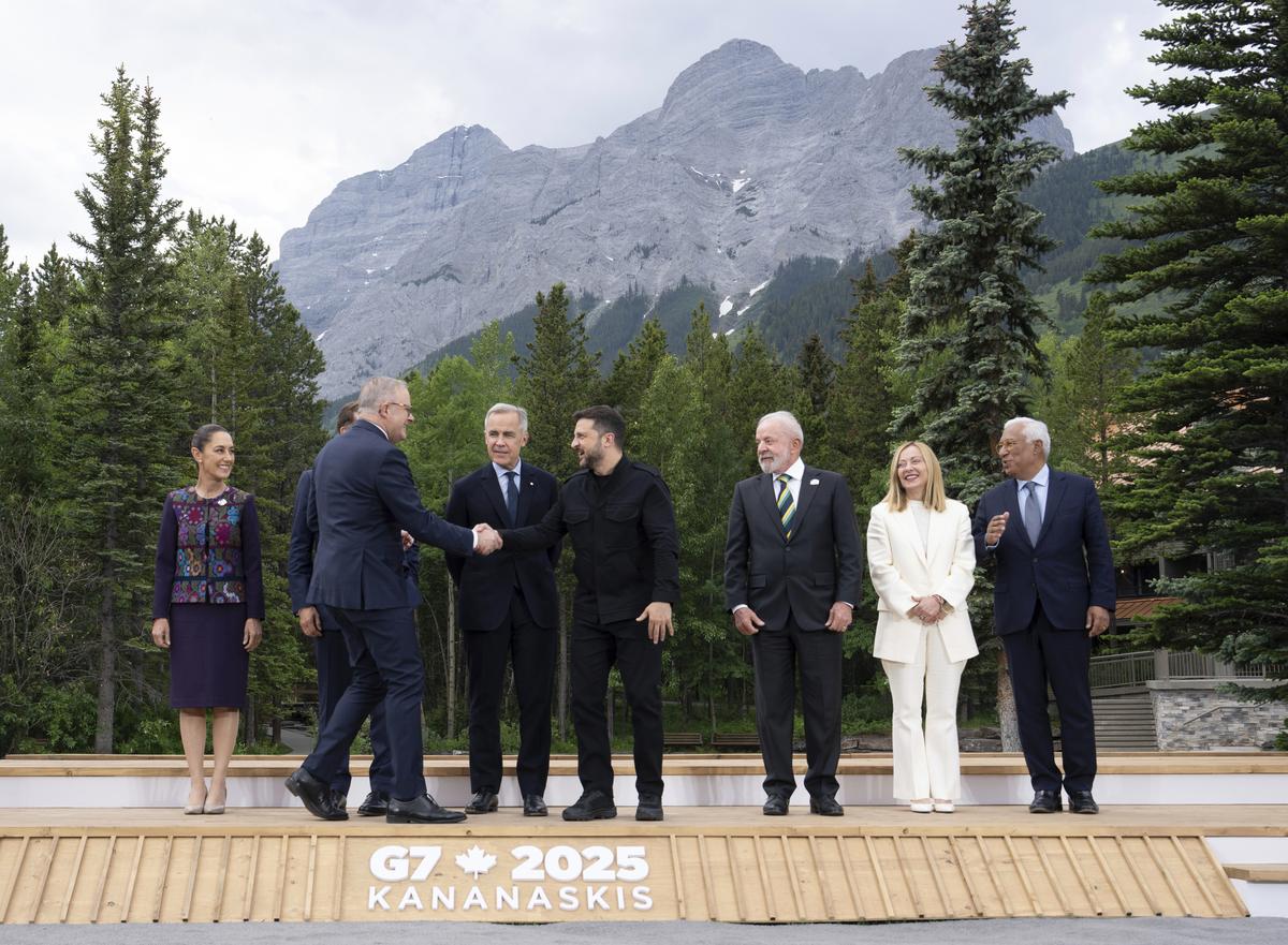 Canada’s Prime Minister Mark Carney, looks on as Australian Prime Minister Anthony Albanese shakes hands with Ukrainian President Volodymyr Zelenskyy, center, as leaders and invited guests take their places for a photo at the G7 Summit, Tuesday, June 17, 2025, in Kananaskis, Alberta. Canada’s Prime Minister Mark Carney, looks on as Australian Prime Minister Anthony Albanese shakes hands with Ukrainian President Volodymyr Zelenskyy, center, as leaders and invited guests take their places for a photo at the G7 Summit, Tuesday, June 17, 2025, in Kananaskis, Alberta.