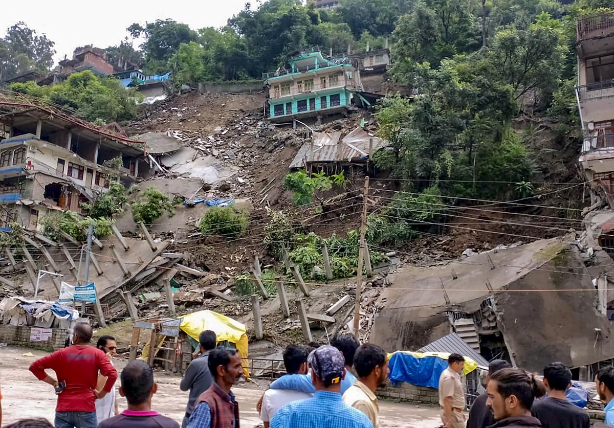 Locals at the site after several buildings collapsed due to a rain-triggered landslide at Anni, in Kullu district on August 24, 2023.