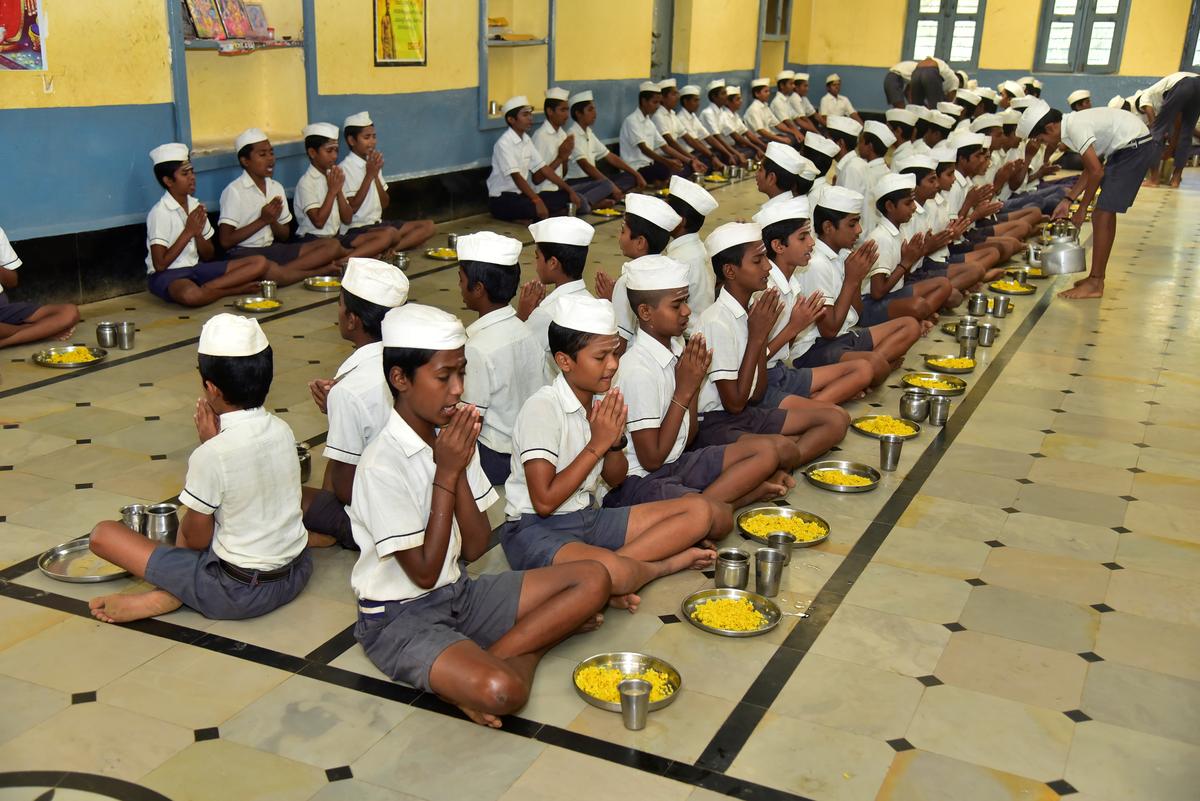 Students of Gandhi Grameen Gurukul Residential School at Hosaritti in Haveri district of Karnataka pray before having their breakfast at the Prasada Nilaya (Dining Hall).  