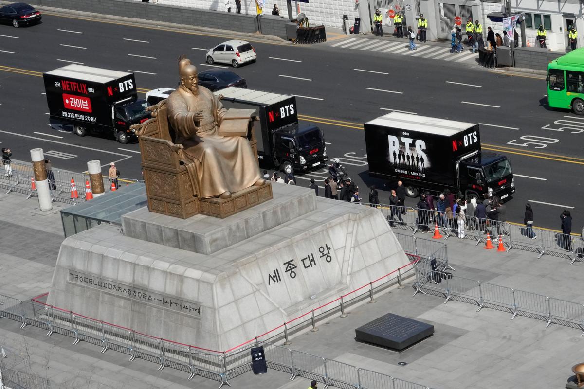 Trucks promoting a comeback concert of K-pop boy group pass by the statue of King Sejong at Gwanghwamun Square in Seoul, South Korea, Thursday, March 19, 2026.