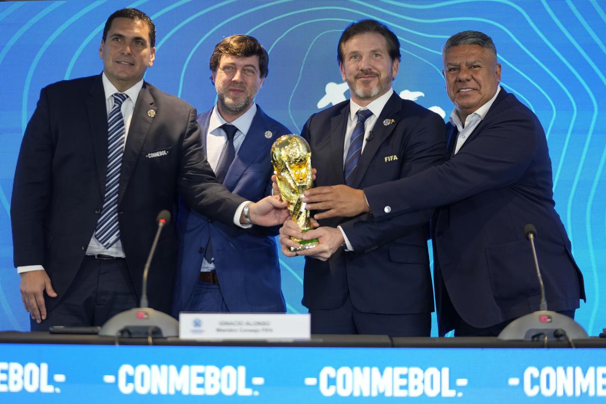Paraguay’s Soccer Association President Robert Harrison, left, FIFA delegate Ignacio Alonso, center, Conmebol President Alejandro Dominguez, third from left, and Conmebol Vice President Claudio Tapia hold the World Cup trophy in Luque, Paraguay, on October 4, 2023. 
