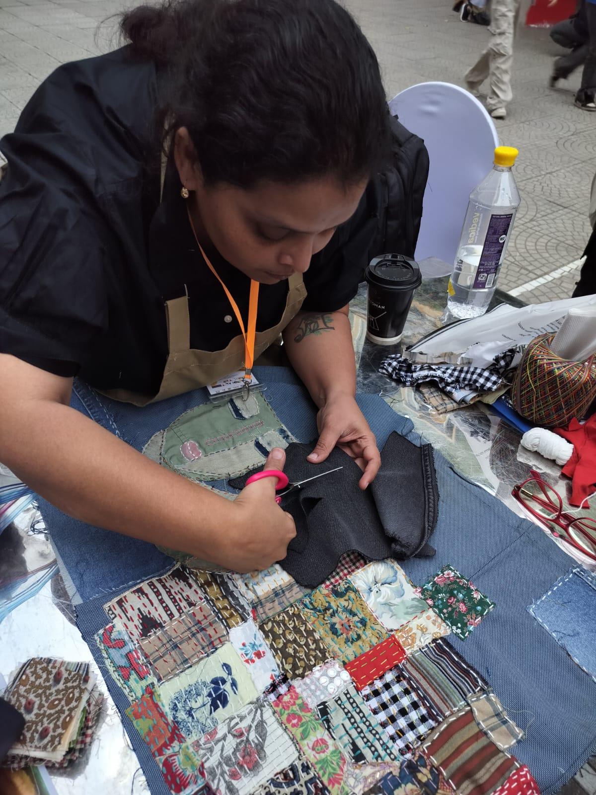 Priti Samyukta cuts a fabric to stitch the layers for quilt art