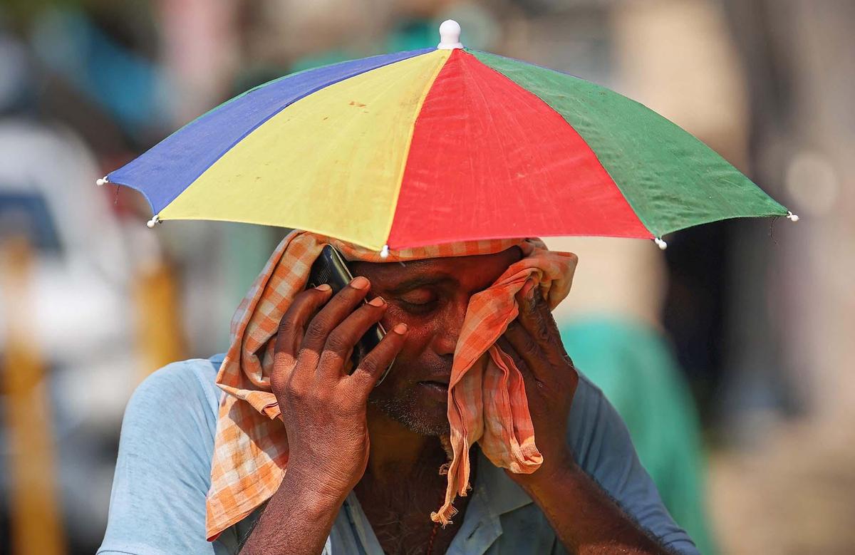 Sun shield: A man shields himself from rising temperatures during a hot summer evening in New Delhi.