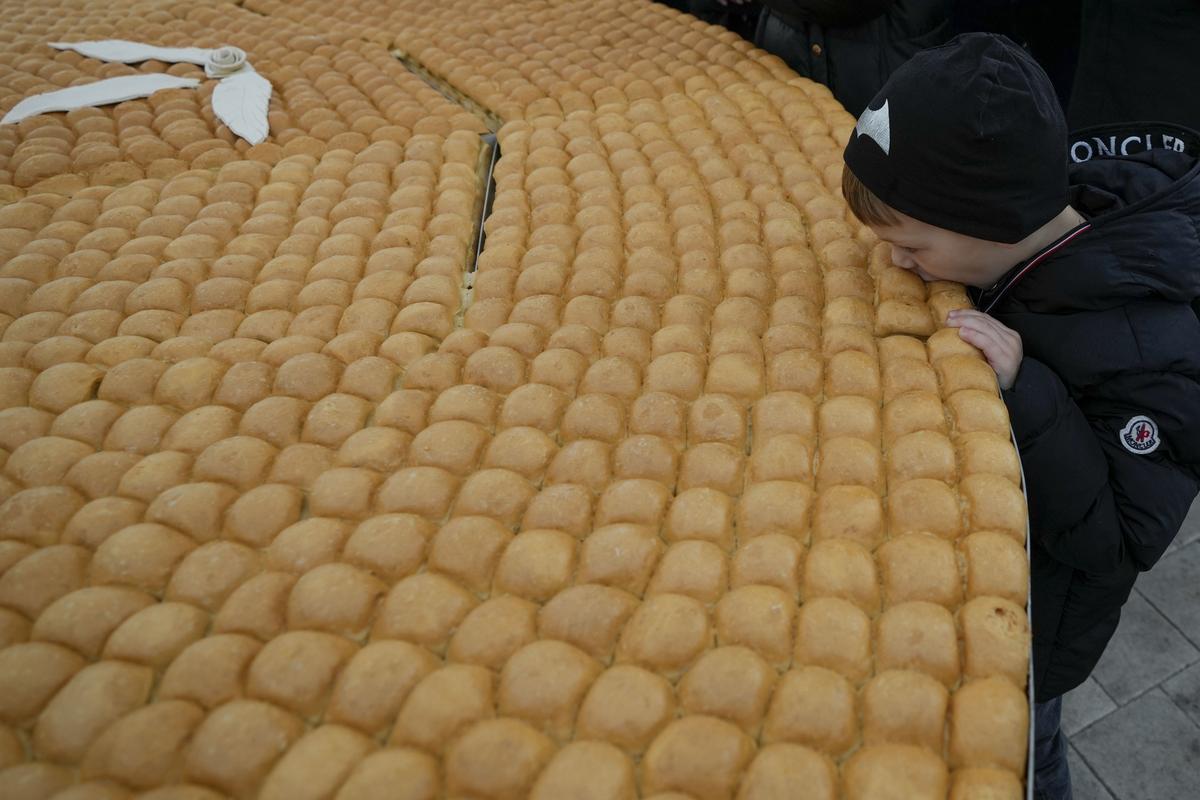 A boy bites traditional Christmas bread to mark the Orthodox Christmas Day festivities in Belgrade, Serbia on January 7, 2024. 