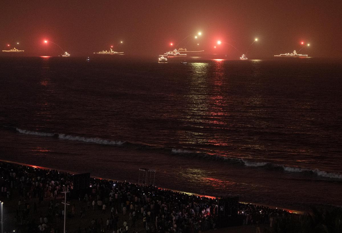 Illuminated ships fire flares during the International City Parade, a highlight of the ongoing MILAN-2026 naval exercise in Visakhapatnam.  