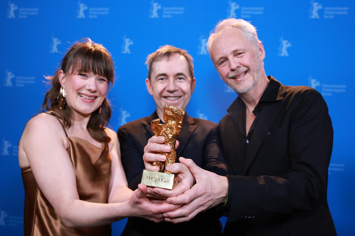 Norwegian director and screenwriter Dag Johan Haugerud (C) and producers Yngve Saether (L) and Hege Hauff Hvattumon pose with the Golden Bear for “Dreams (Sex Love)“ backstage during the awards ceremony of the 75th Berlinale International Film Festival Berlin on February 22, 2025 in Berlin, Germany.