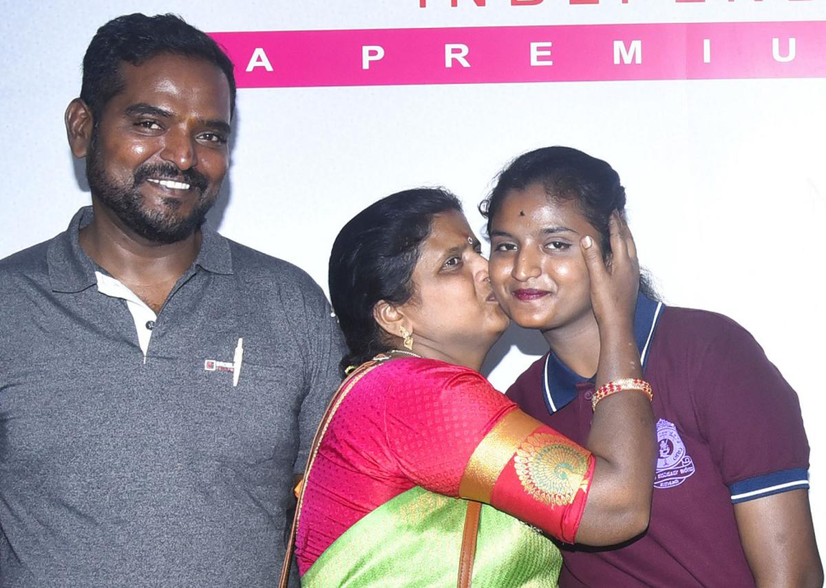 Gnanavi M. topper in the Commerce stream being greeted by  her parents.