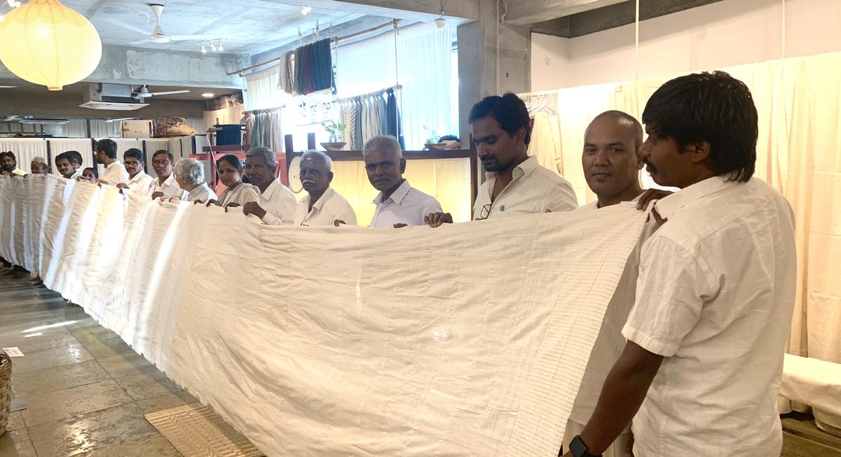 Dharmendra Vaddepalli (second from right) with weavers displaying the fabric during launch
