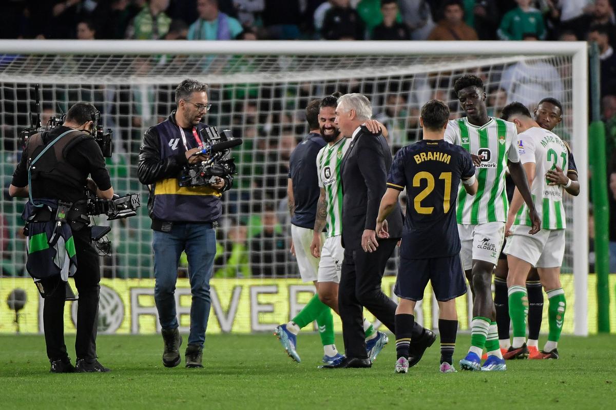 Real Madrid’s coach Carlo Ancelotti reacts with Real Betis’ Spanish midfielder #22 Isco at the end of during the Spanish league football match between Real Betis and Real Madrid CF at the Benito Villamarin stadium.