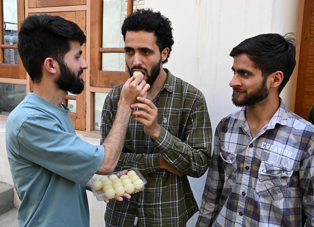 Family members of Engineer Rashid, including his son Abrar Rashid, exchange sweets as Engineer Rashid secures early lead to win Baramulla Lok Sabha seat in Srinagar, on Tuesday, June 4, 2024.  