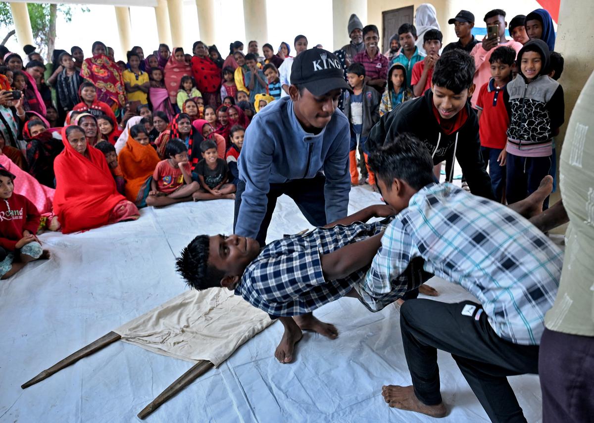 Volunteers evacuate a man playing a mock victim during a mock drill to prepare against tsunami in Kendrapara district in the eastern state of Odisha on December 21, 2024.