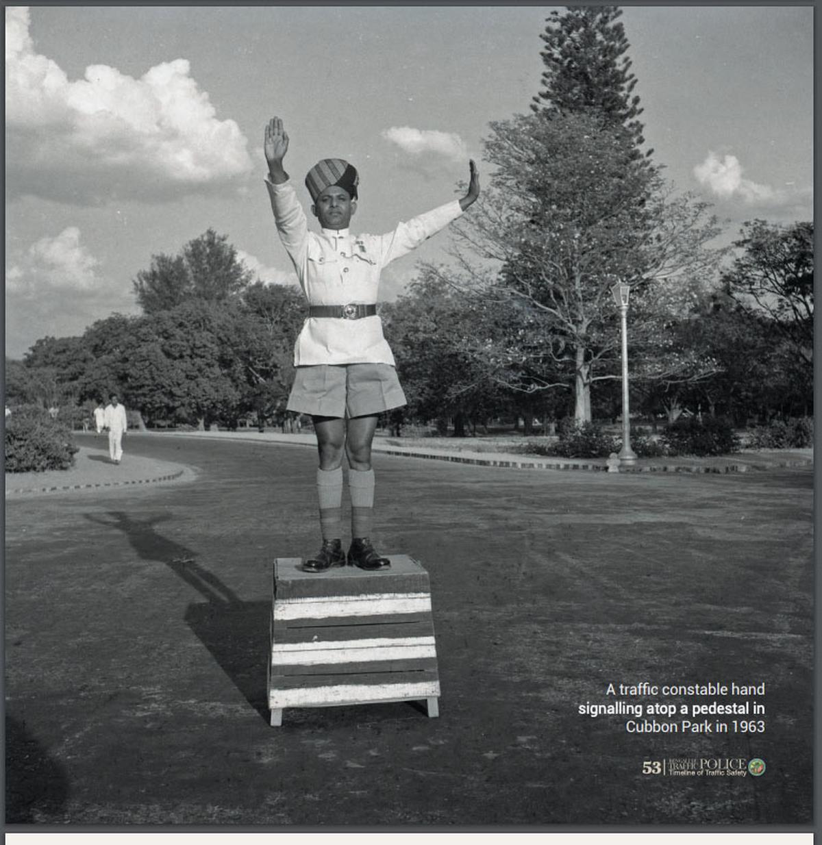 A traffic constable hand-signalling standing atop a pedestal in Cubbon Park in 1963