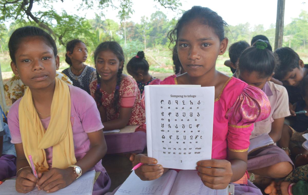 A Savara girl displays a textbook contains 24 letters of the Savara script, during a special class at Addangi village in Seetampeta Agency.