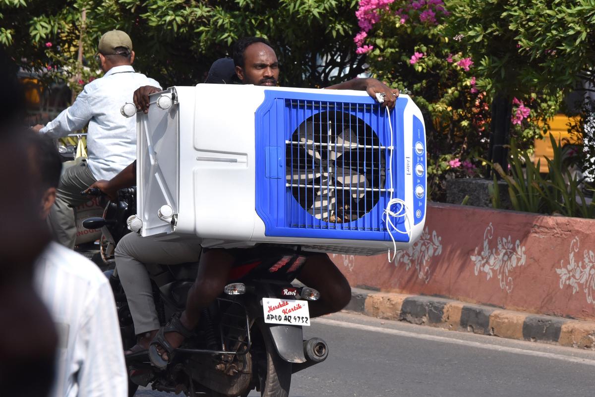 A man carrying a newly bought air cooler on his two-wheeler in Kurnool on Thursday, amid the severe heat. A man carrying a newly bought air cooler on his two-wheeler in Kurnool on Thursday, amid the severe heat.