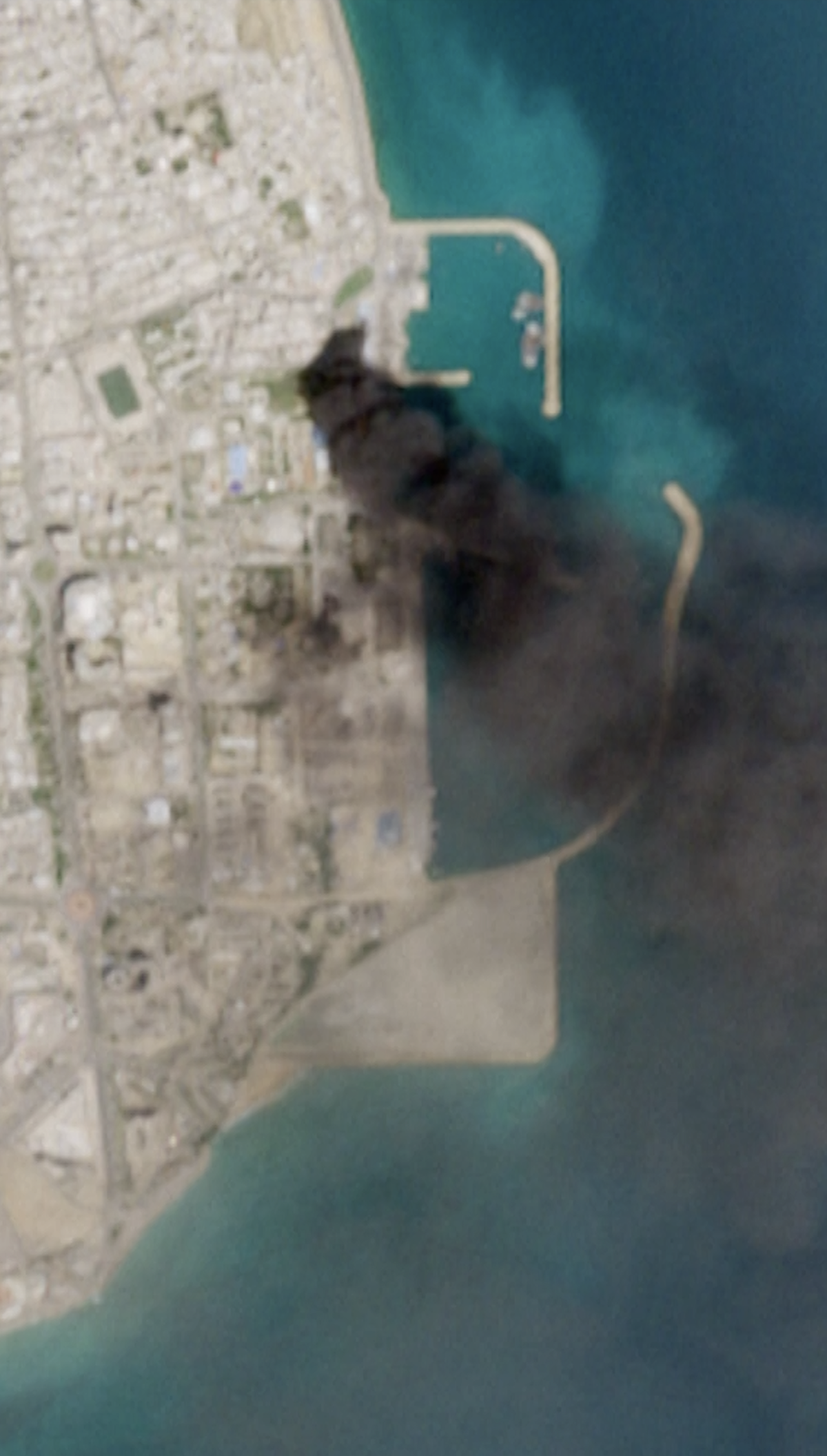 A satellite image shows smoke rising from Iran port