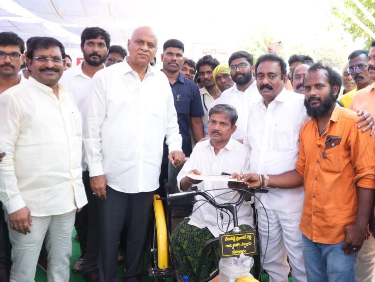 Nellore MP Vemireddy Prabhakar Reddy presenting a tricycle through his VPR Foundation to a beneficiary in Kavali of SPSR Nellore district on Sunday. Kavali MLA Kavya Krishna Reddy and MLC Beeda Ravichandra are seen.