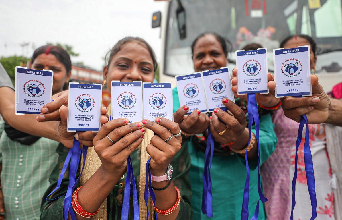 Pilgrims display their Radio Frequency Identification (RFID) tags after getting themselves registered for the Amarnath yatra in Jammu.