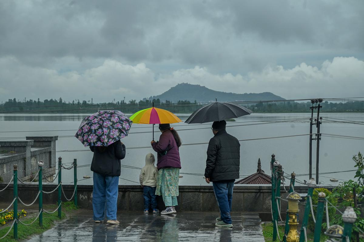 Visitors enjoy the Mughal garden during rainfall in Srinagar on April 19, 2025.