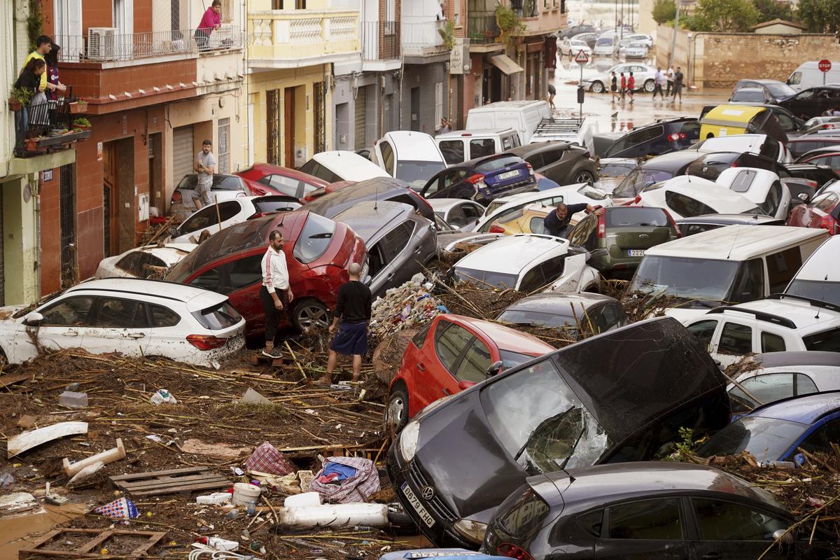 Residents look at cars piled up after being swept away by floods in Valencia, Spain on Wednesday (October 30, 2024).