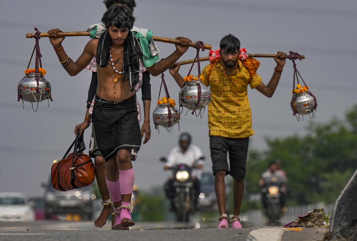 Lord Shiva devotees or ‘Kanwariyas’ carrying holy water from the Ganga river during their pilgrimage in the month of ‘Shravan’, in New Delhi, Friday, July 7, 2023. 