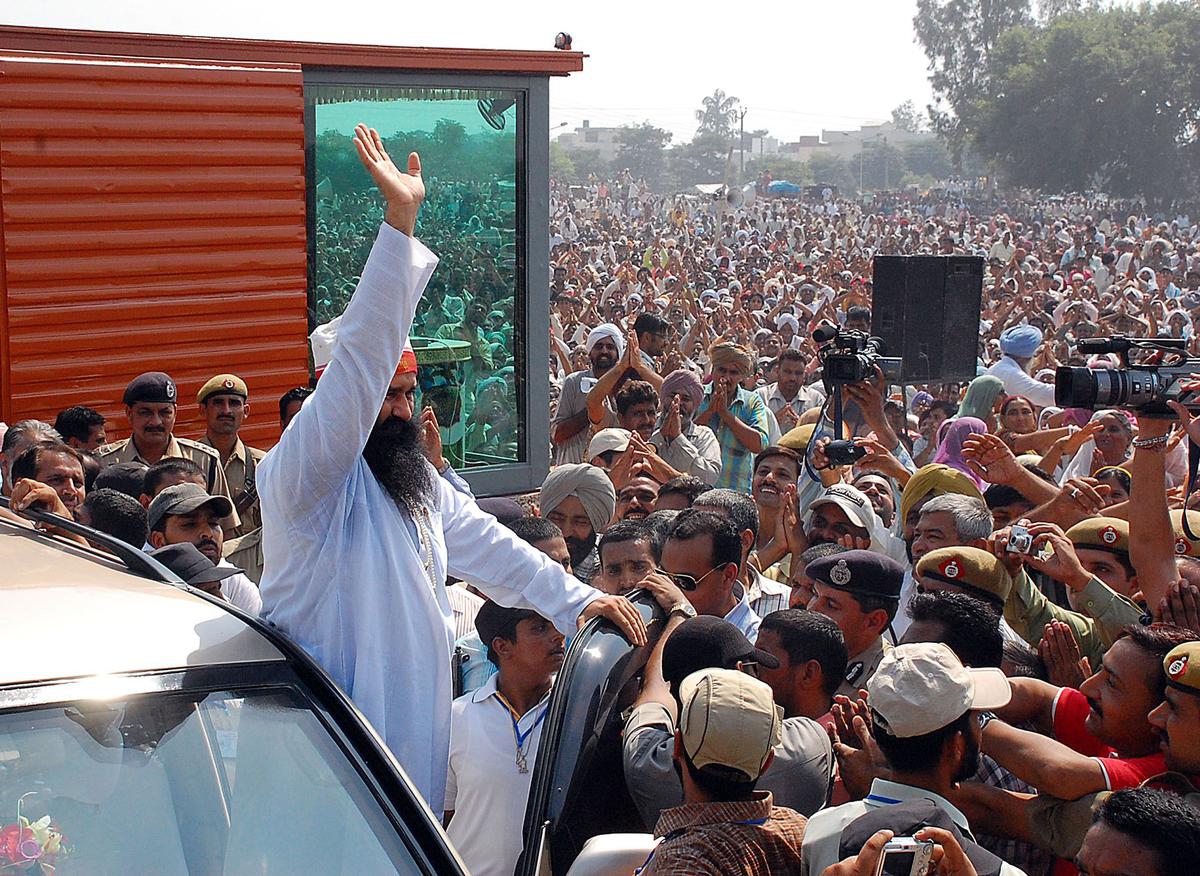 Dera Sacha Sauda chief Gurmeet Ram Rahim Singh waves to his followers after securing bail from the special CBI court, at Ambala on October 4, 2007.