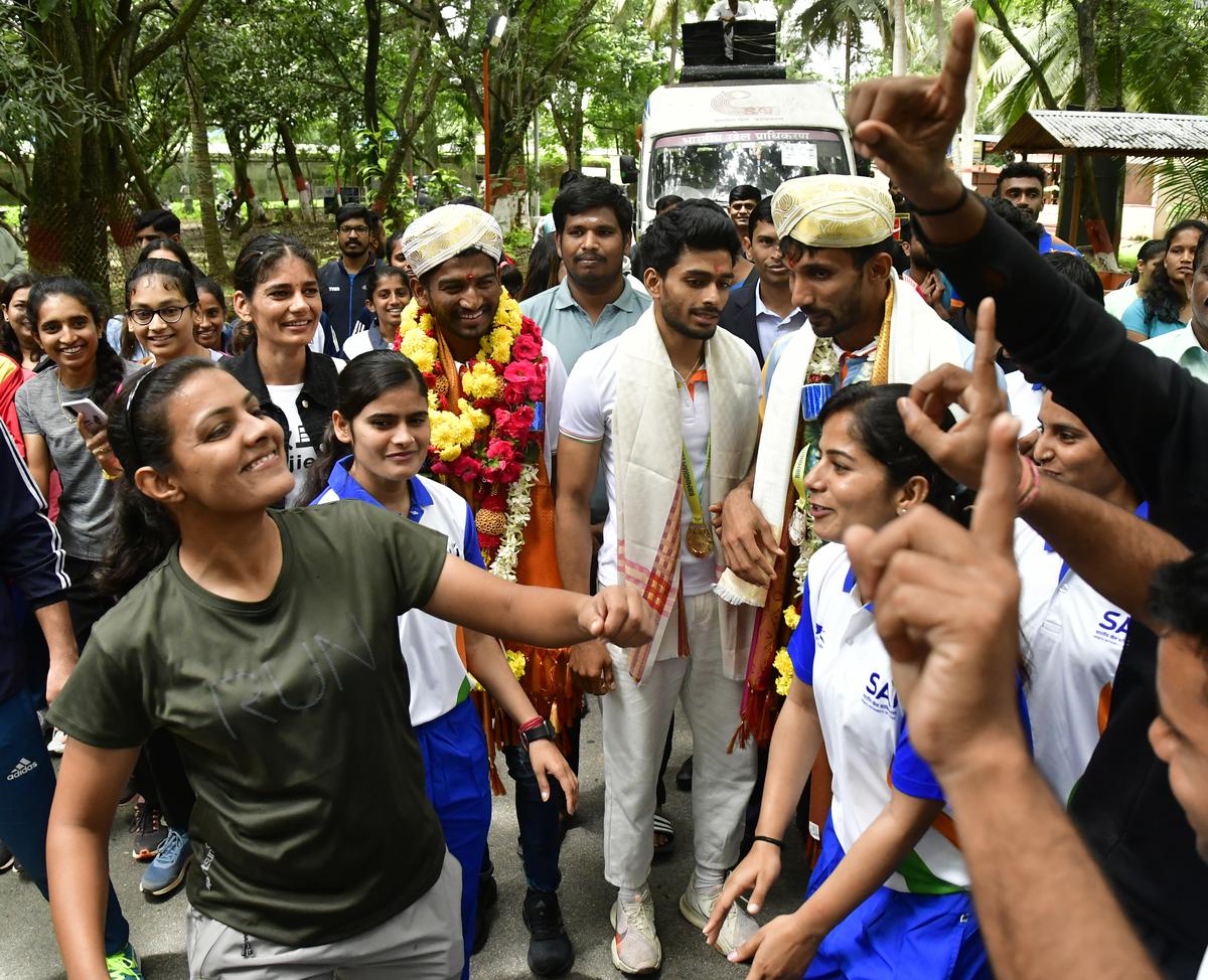 Fans break out into a dance while welcoming CWG 2022 triple jump gold medallist Eldhose Paul, silver medallist Abdulla Aboobacker, and 3000m steeplechase silver medallist Avinash Sable, at the SAI (Sports Authority of India), South Centre, in Bengaluru on August 09, 2022. 