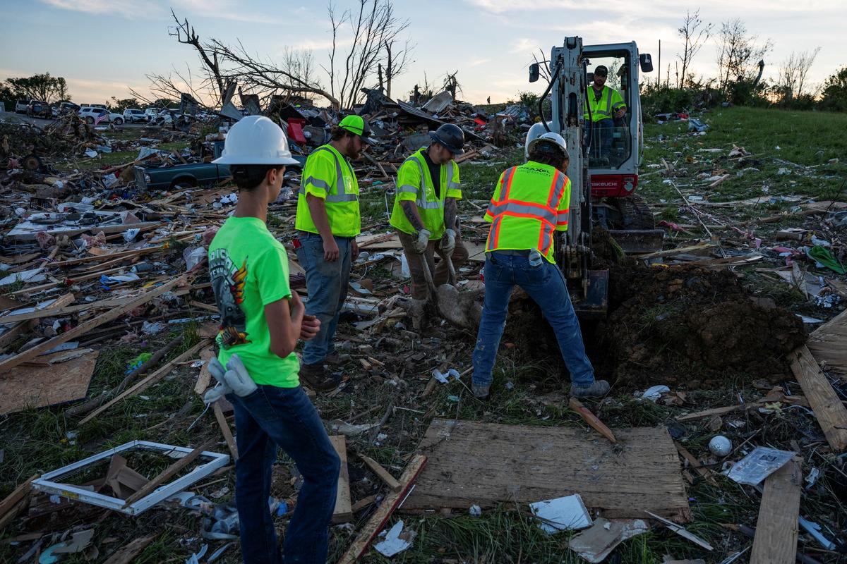 workers bury a dog found among the debris in the Sunshine Hills neighborhood after a series of tornadoes hit in London, Kentucky, U.S., May 17, 2025.  