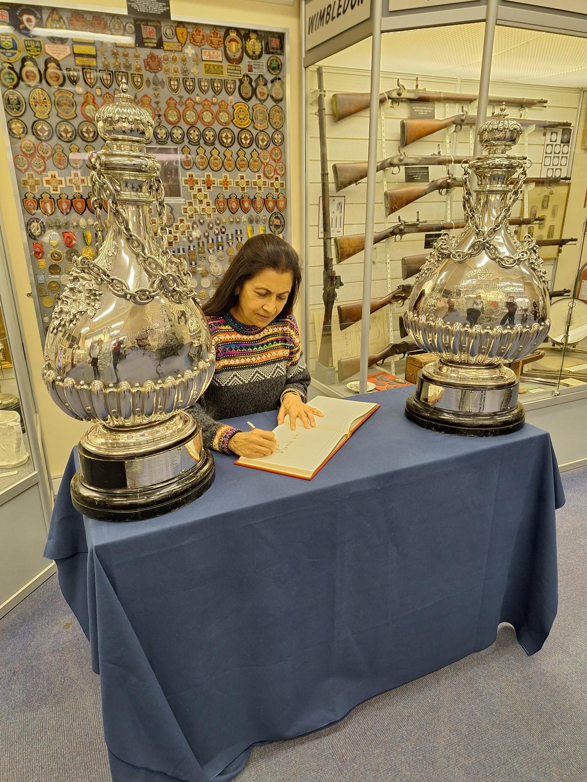 Vidya Singh signing the visitors’ book, seated between the Vizianagram trophies 