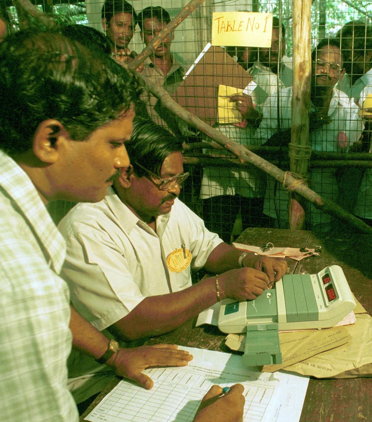 Officials incharge of counting unlock an EVM machine to start the counting process at Presidency College premises in Chennai on April 15, 2001.