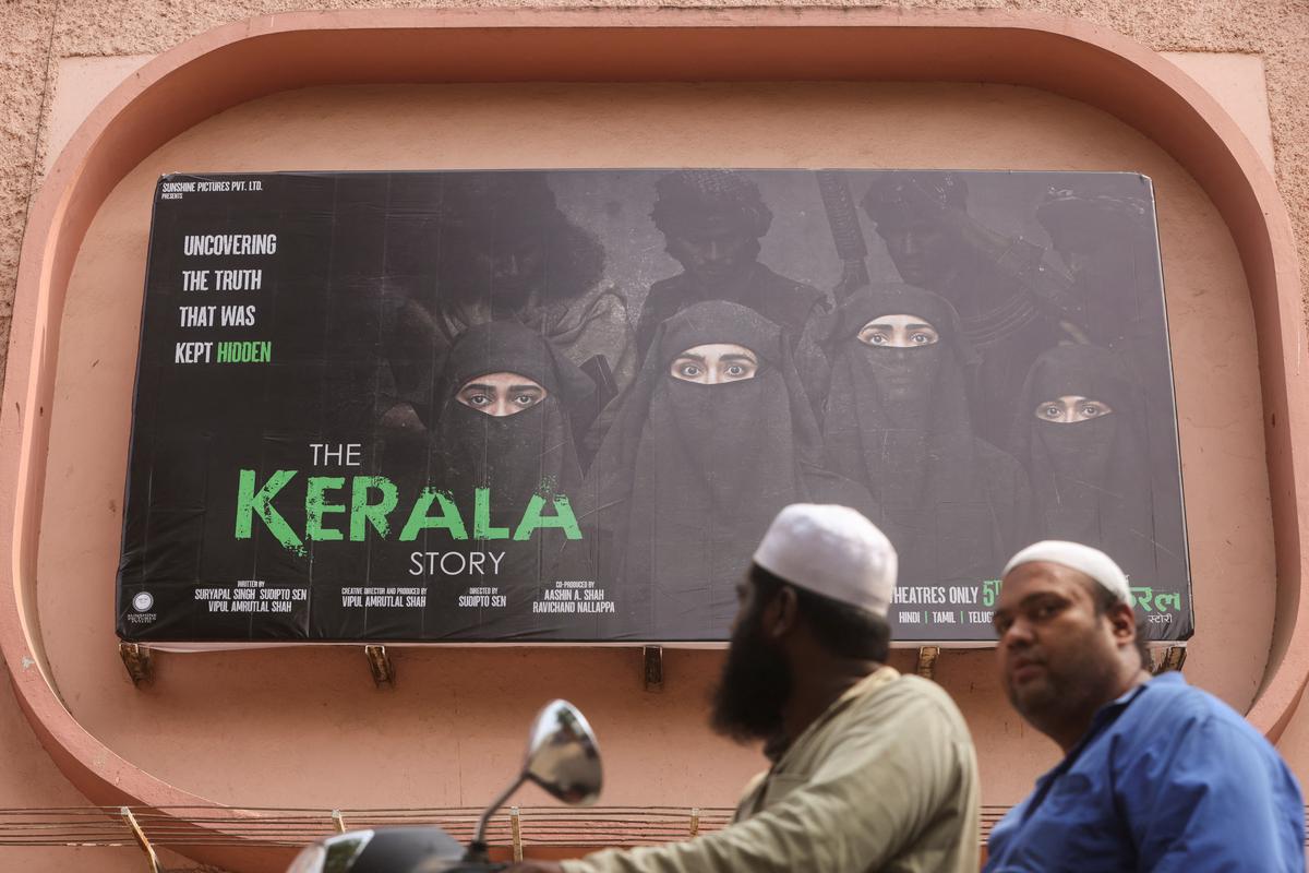File picture of people riding past a poster of ‘The Kerala Story’