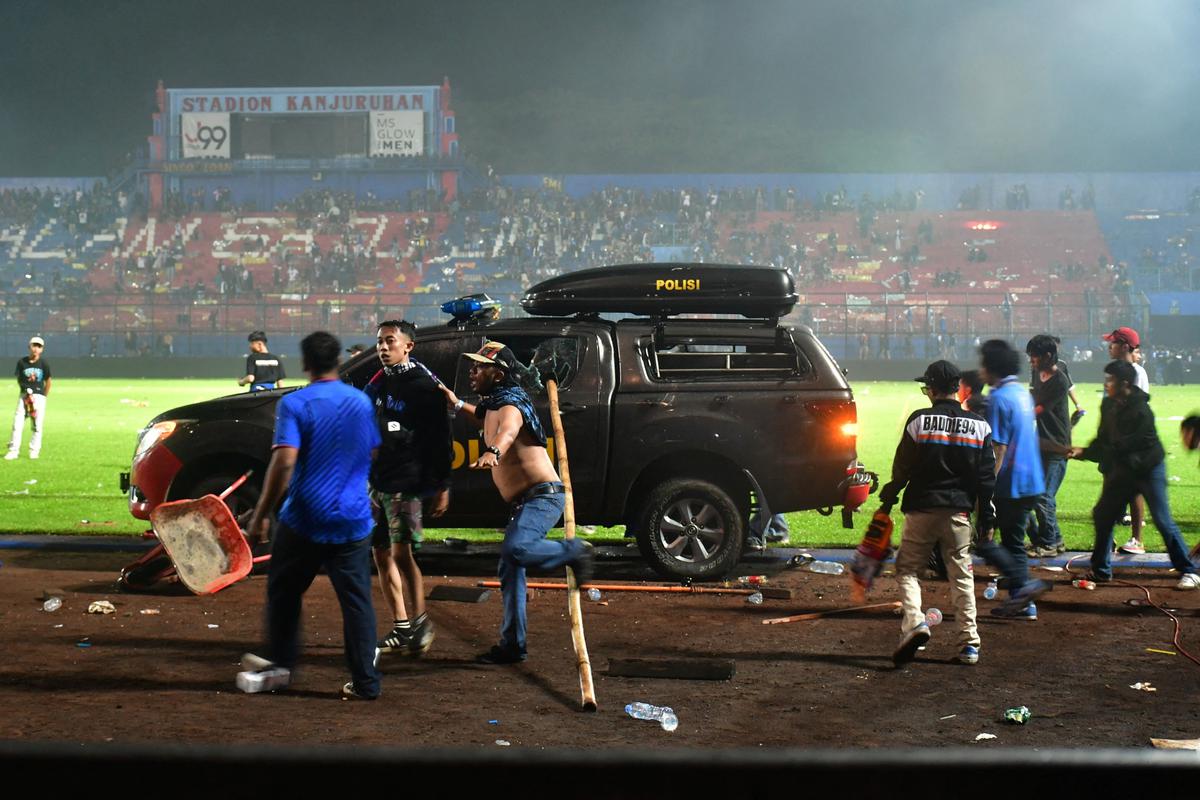 Supporters enter the field during the riot after the football match between Arema vs Persebaya at Kanjuruhan Stadium, Malang, East Java province, Indonesia, on October 2, 2022. 