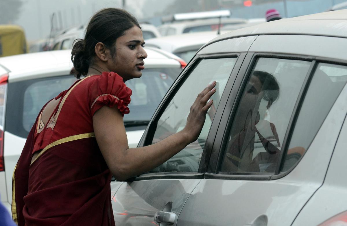 Una persona transgénero es vista pidiendo limosna en un semáforo