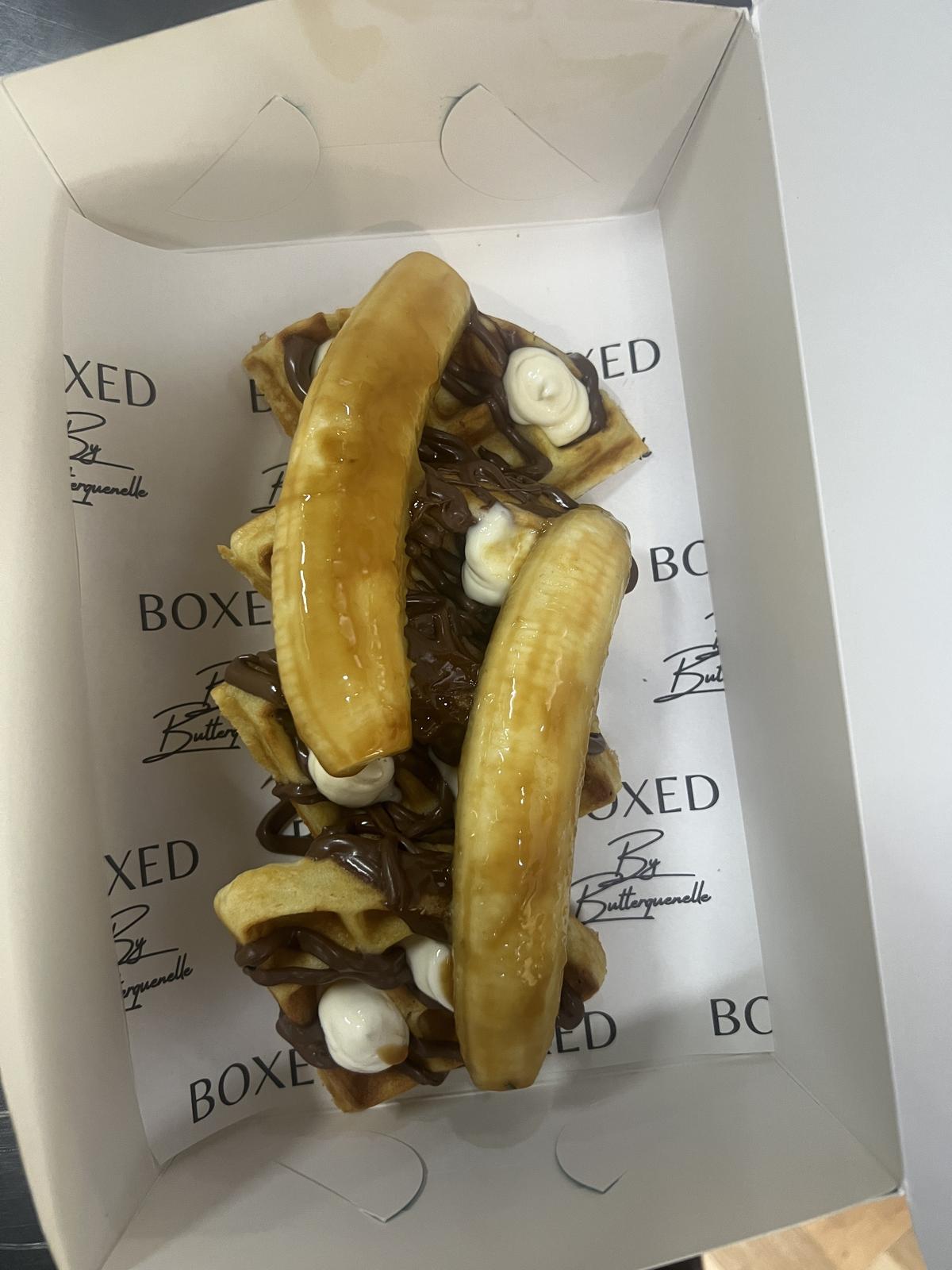 Nutella banana waffle topped with chocolate spread and ripe banana is decadent