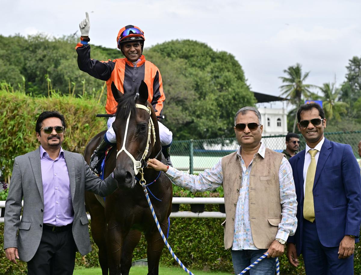 Owners Ashok Ranpise, second right, and Teja Gollapudi, left, along with trainer Rajesh Narredu, right, leading in Excellent Lass (jockey Suraj Narredu) after winning The Fillies Championship Stakes, at the BTC, in Bengaluru on August 03, 2024.