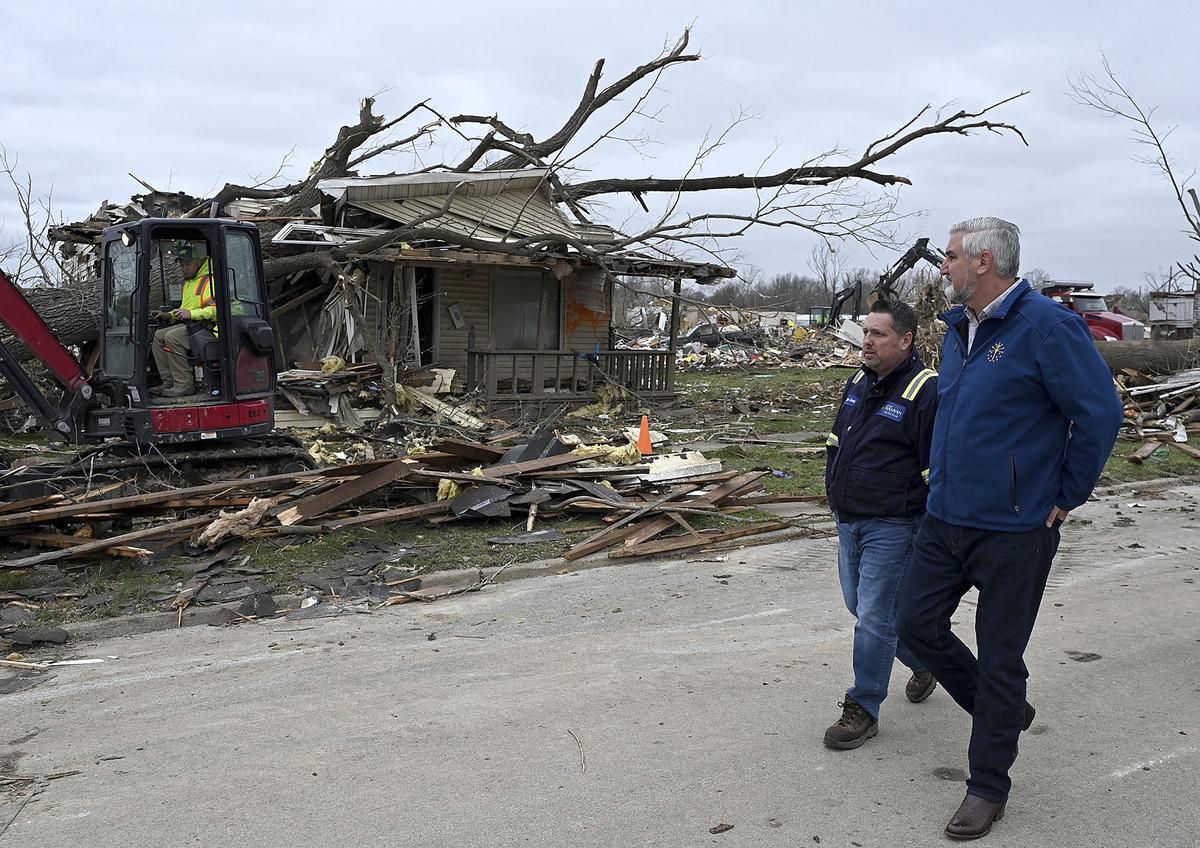 Sullivan Mayor Clint Lamb and Indiana Governor Eric Holcomb survey the damage caused by a tornado on Saturday, April 1, 2023 in Sullivan, Indiana. 