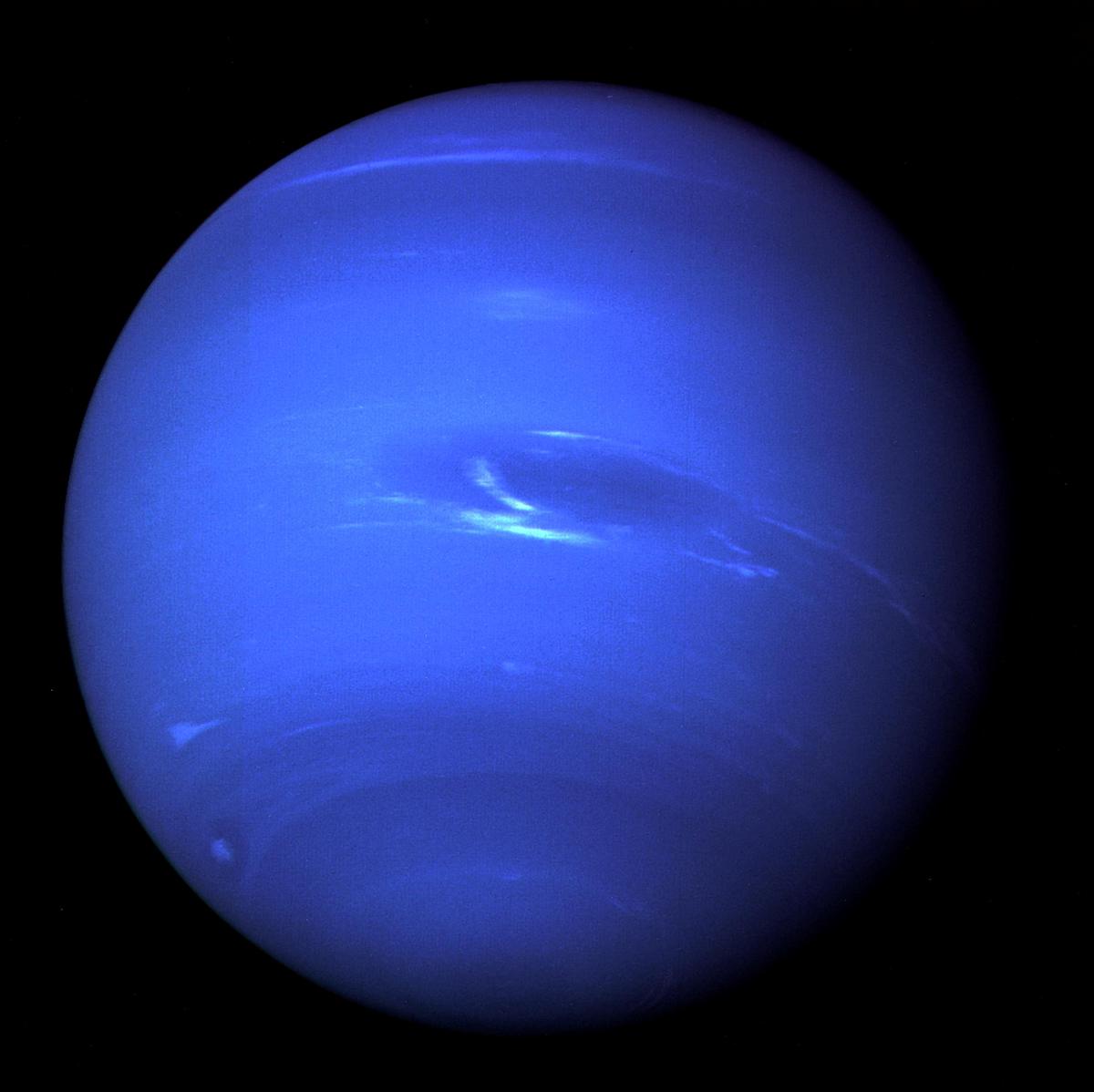 The “Great Dark Spot”, a storm in the atmosphere and the bright, light-blue smudge of clouds that accompanies the storm is seen on the planet Neptune, taken by the Voyager 2 less than five days before its closest approach of the planet on August 25, 1989. 