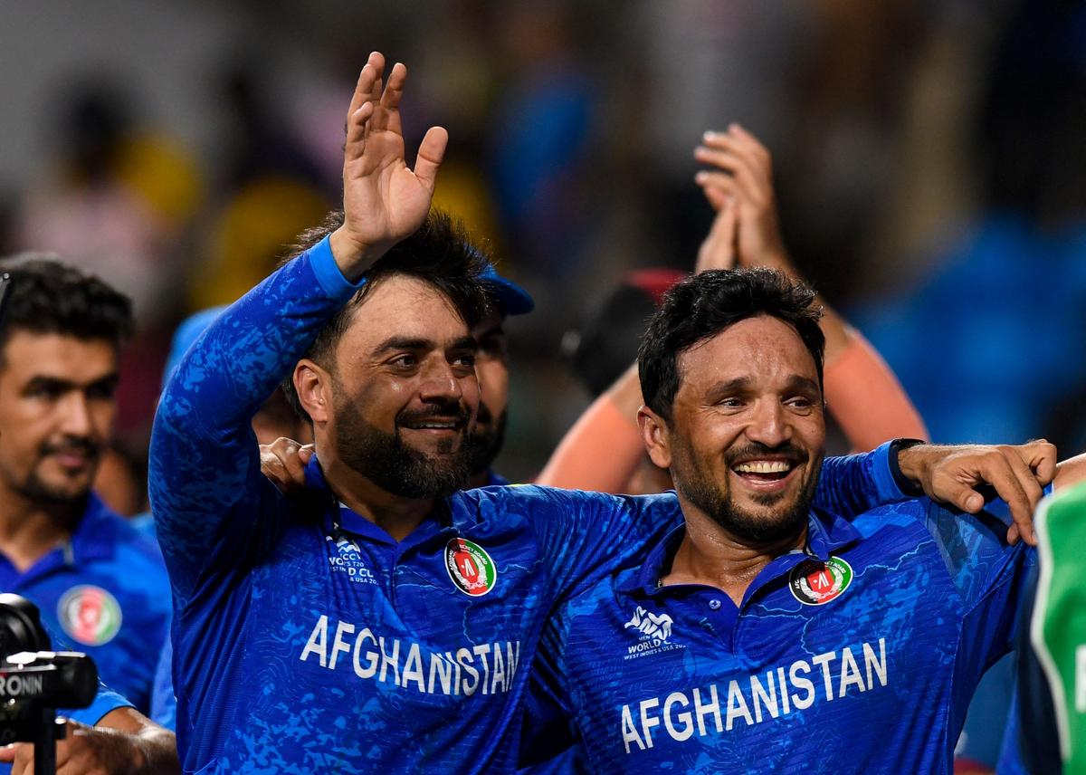 Afghanistan's captain Rashid Khan (L) and Afghanistan's Gulbadin Naib celebrate winning their the ICC men's Twenty20 World Cup 2024 Super Eight cricket match against Bangladesh at Arnos Vale Stadium in Arnos Vale, Saint Vincent and the Grenadines on June 24, 2024. (Photo by Randy Brooks / AFP)