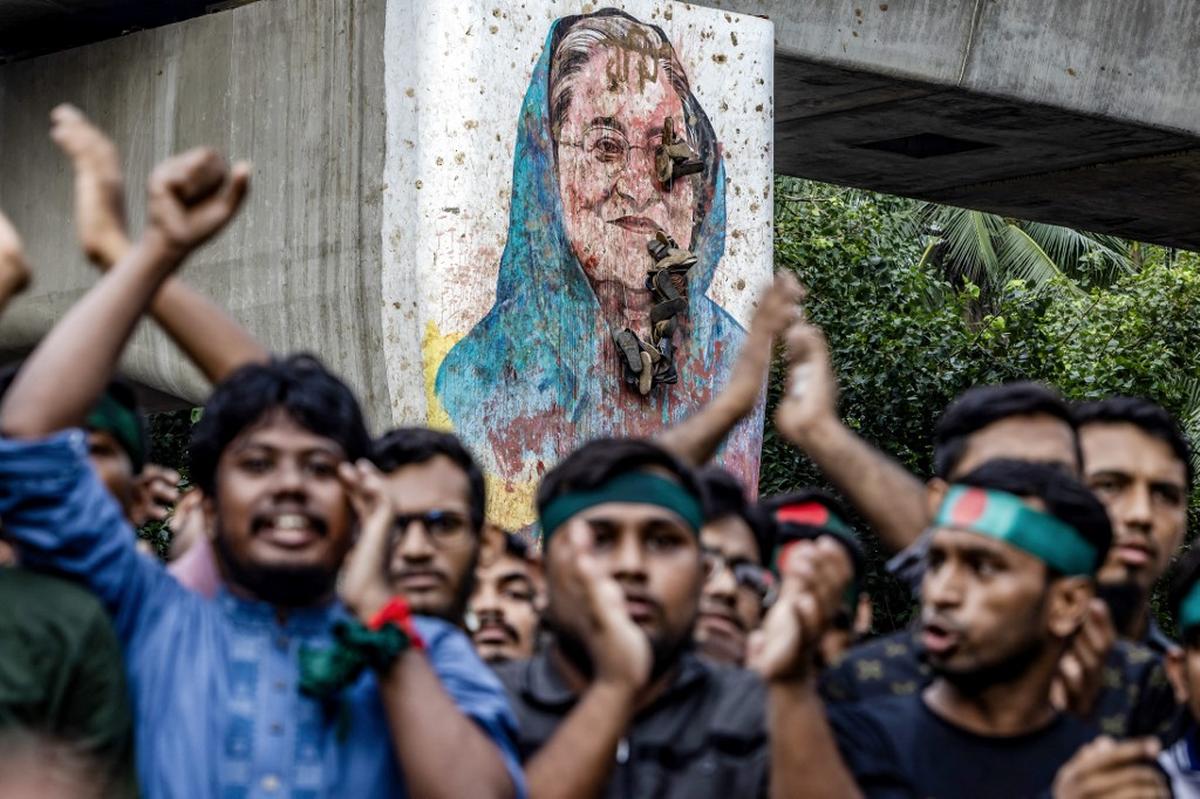 Students chant slogans near a vandalised mural of Bangladesh’s ousted Prime Minister Sheikh Hasina near Dhaka University in the capital on August 12, 2024. 