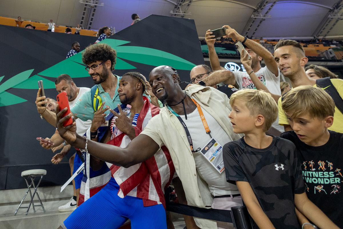 Noah Lyles poses for photographs with fans after the men’s 4x100m relay gold medal win during the 2023 World Athletics Championships