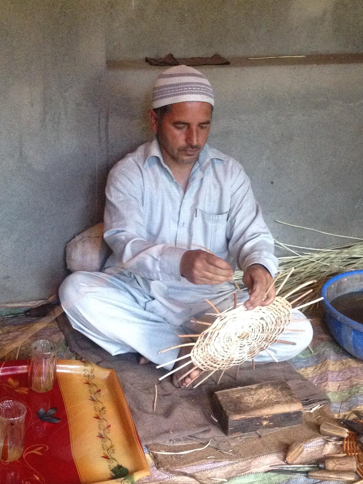 An artisan weaving a wicker basket