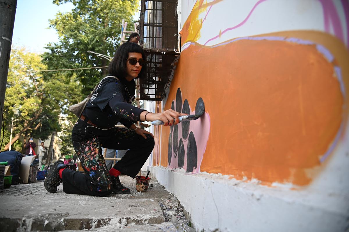 Berlin-based artist Jumu works on her mural, Magical