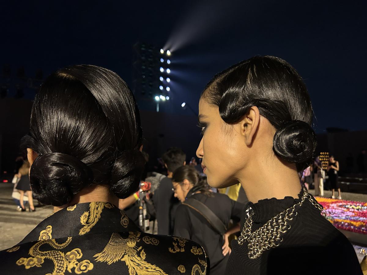 In addition to the waxed finger waves of the 1920s, models also wore twin buns;  See here, Pooja Mor and Sumaya.