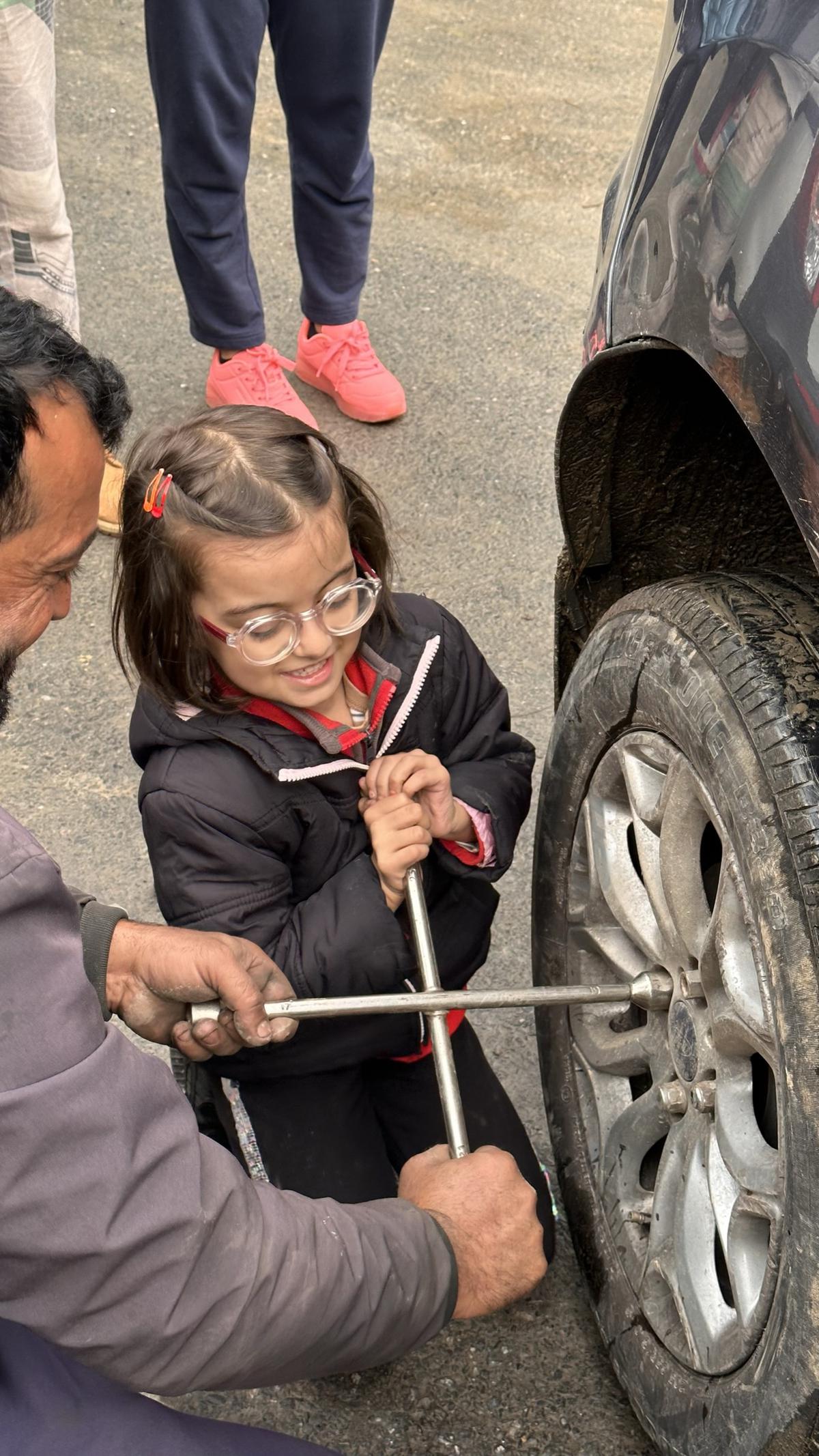 Beyla helping change a tyre