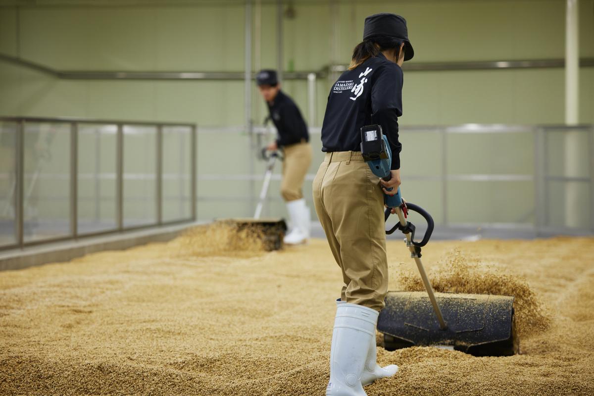 Workers at Suntory Yamazaki Distillery move the malt Workers at Suntory Yamazaki Distillery move the malt