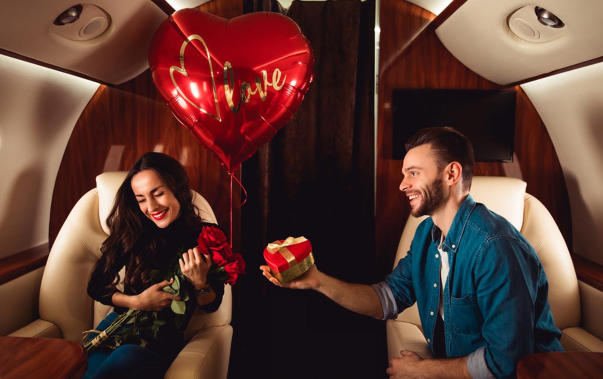 A man giving a present to his wife while taking a flight