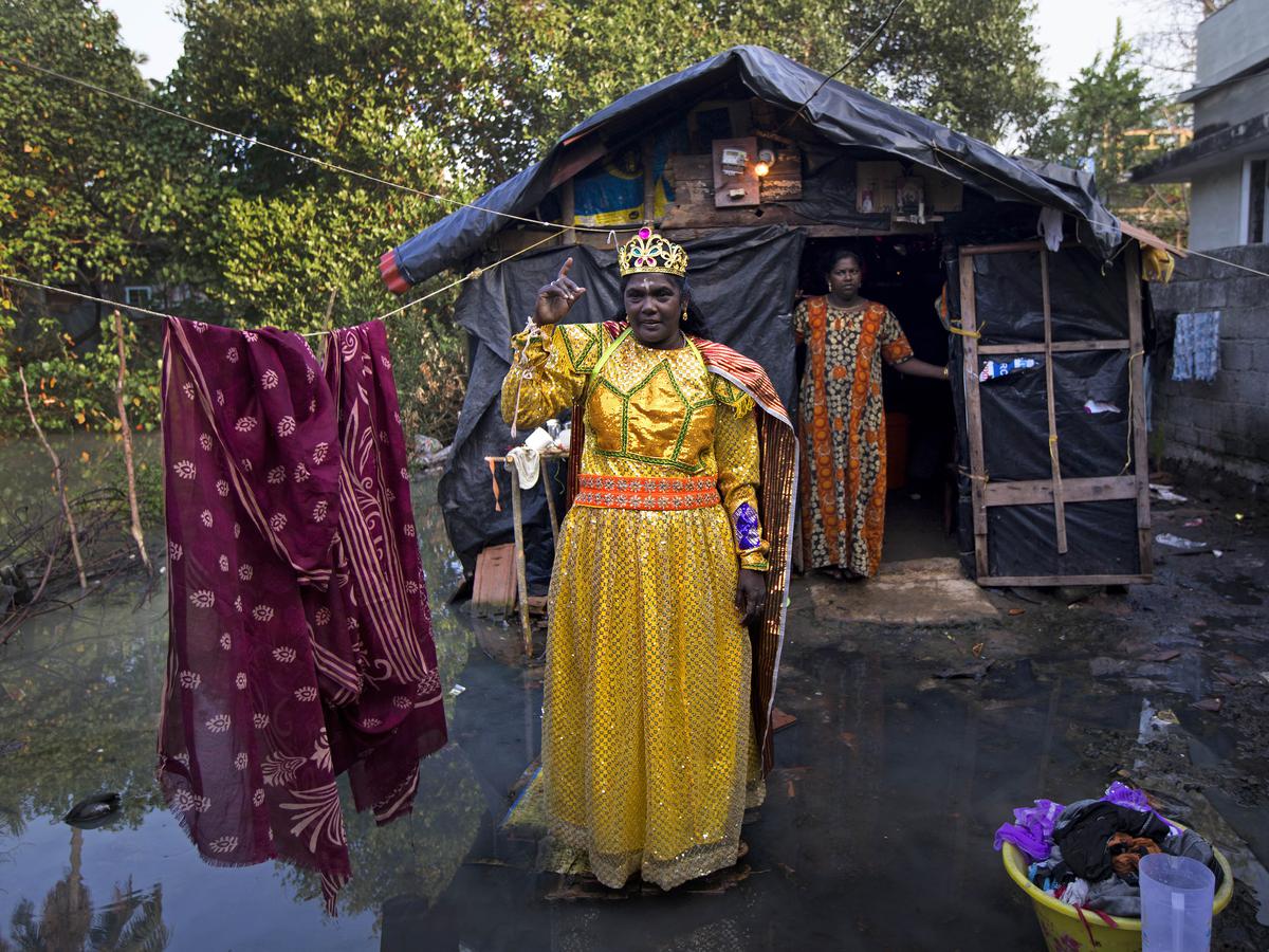 Alphonsa poses as a queen outside her hut that’s surrounded by water